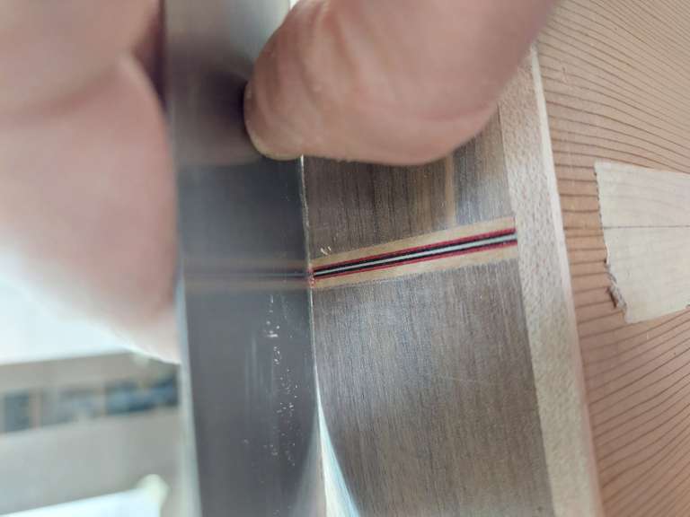 Photo illustrant un luthier travaillant au racloir